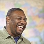 Man laughing in front of map of United States
