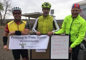 Jeff and two riders hold "Pedaling to Train Nurses" sign